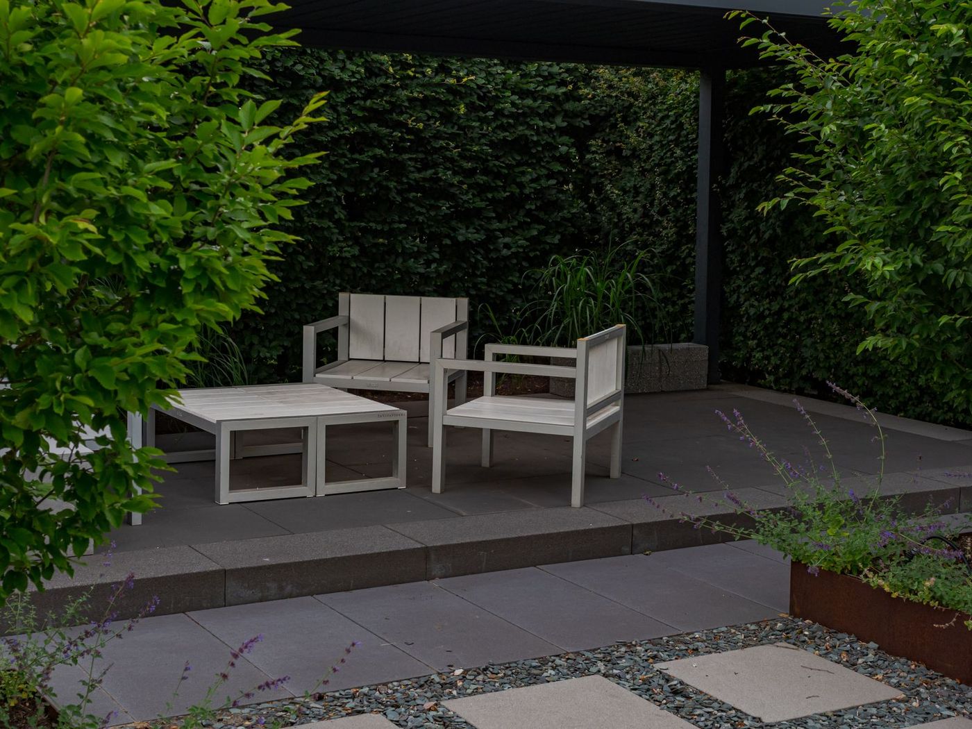 Home Paved patio with seating and a clipped hedge behind