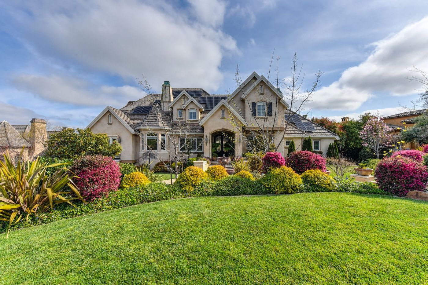 Home Stone cottage with a planted front garden and lawn in summer