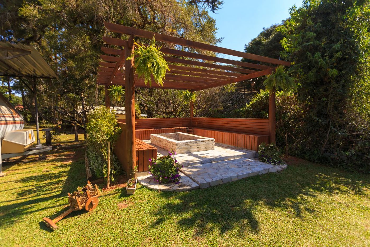 Timber pergola over a paved seating area beside a lawn